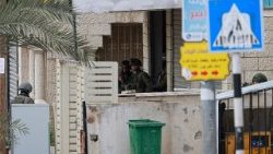 Israeli troops man a position inside a building at the entrance of the occupied West Bank