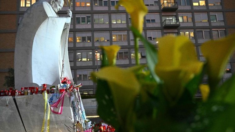 Flowers are laid near the statue of St. John Paul II outside the Gemelli hospital