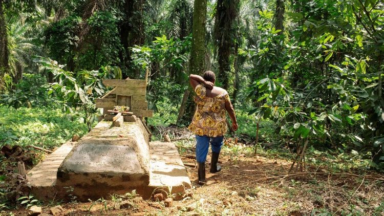 Judith Kahindo, 40 ans, originaire de la province d'Ituri et déplacée par les massacres du groupe armé Allied Democratic Forces (ADF) en 2021, marche à côté de la tombe de son père dans son champ à Mavivi, à la périphérie de Beni, au Nord-Kivu.