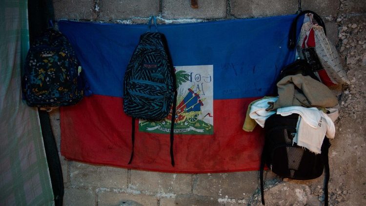 Backpacks and belongings of a family who fled gang violence hang on the wall in a newly opened shelter near the National Palace in Port-au-Prince