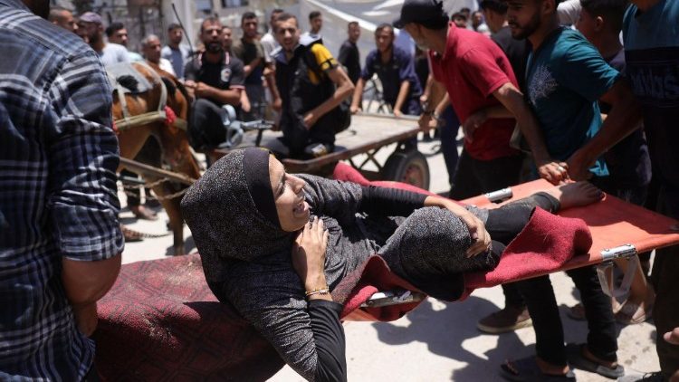 Una donna in barella a Gaza dopo un attacco israeliano