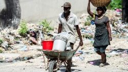 Haitianos carregam mercadorias pelo centro de Porto Príncipe em 21 de julho.