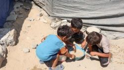 Palästinensische Kinder teilen sich eine Schüssel Linsensuppe, die sie am 1. August 2025 an einer Lebensmittelausgabestelle in Gaza-Stadt erhalten haben (Foto: Omar AL-QATTAA / AFP)