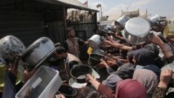 Palestinos mostram suas panelas vazias em frente a um refeitório comunitário em Khan Yunis, na Faixa de Gaza, no sul da Palestina.
