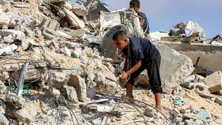 Palestinian children amid the rubble of a bombed tower in Gaza City