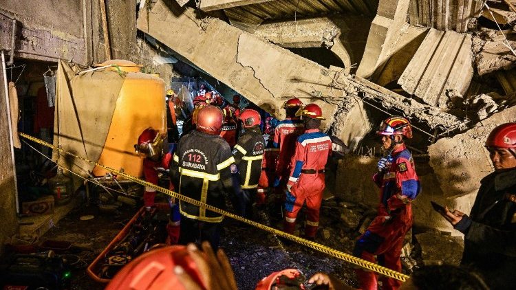 I soccorsi scavano tra le macerie di un edificio scolastico crollato nella provincia est di Giava in Indonesia
