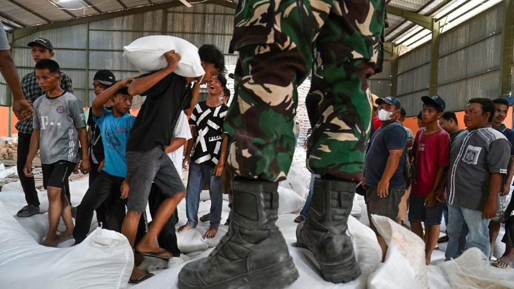 Moradores recebem sacos de arroz gratuitos do exército indonésio, distribuídos em meio aos esforços de ajuda humanitária a partir do armazém de arroz do governo em Sarudik, na região central de Tapanuli, província de Sumatra do Norte, em 3 de dezembro de 2025. Autoridades da Indonésia e do Sri Lanka lutavam em 3 de dezembro para chegar aos sobreviventes das enchentes mortais em regiões remotas e isoladas, enquanto o número de mortos no desastre que atingiu quatro países ultrapassava 1.300. Na Indonésia, cresce a frustração entre os sobreviventes das enchentes e deslizamentos de terra catastróficos com a lentidão dos esforços de resgate e da entrega de ajuda. (Foto de YT Hariono / AFP)