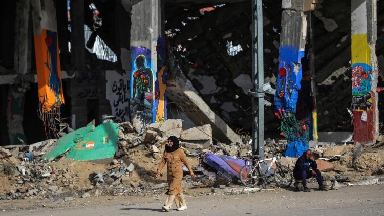 डेर-ल-बल्लाह में टूटे हुए घरों के बगल से पार होती हुई