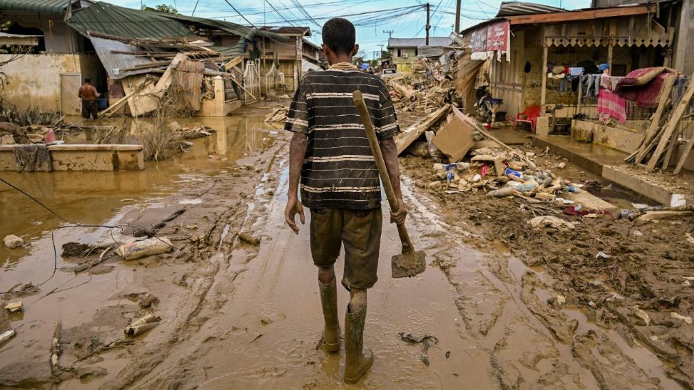 Um homem caminha carregando uma enxada em uma rua ainda cheia de lama após uma enchente repentina atingir a área em Aceh Tamiang, província de Aceh, em 6 de dezembro de 2025. Tempestades tropicais e chuvas de monção atingiram o Sudeste e o Sul da Ásia neste mês, provocando deslizamentos de terra e enchentes repentinas desde as florestas tropicais da ilha de Sumatra, no oeste da Indonésia, até as plantações nas terras altas do Sri Lanka. (Foto de YT HARIONO / AFP)