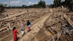 उतरी सुमात्रा के बाढ़ से प्रभावित क्षेत्र में चलती हुई महिलायें