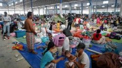 People rest at temporary camp for displaced people set up at a former market in the Banteay Meanchey province on 13 December