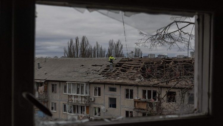 Oper&aacute;rios removem os destro&ccedil;os do telhado de um pr&eacute;dio residencial gravemente danificado ap&oacute;s um ataque de drone em Kiev, em 23 de dezembro de 2025, em meio &agrave; invas&atilde;o russa da Ucr&acirc;nia. Diversas regi&otilde;es ucranianas sofreram cortes de energia em meio ao rigoroso inverno de 23 de dezembro de 2025, ap&oacute;s a R&uacute;ssia lan&ccedil;ar seu mais recente ataque mortal em larga escala com drones e m&iacute;sseis, disseram as autoridades. (Foto de Roman PILIPEY / AFP)