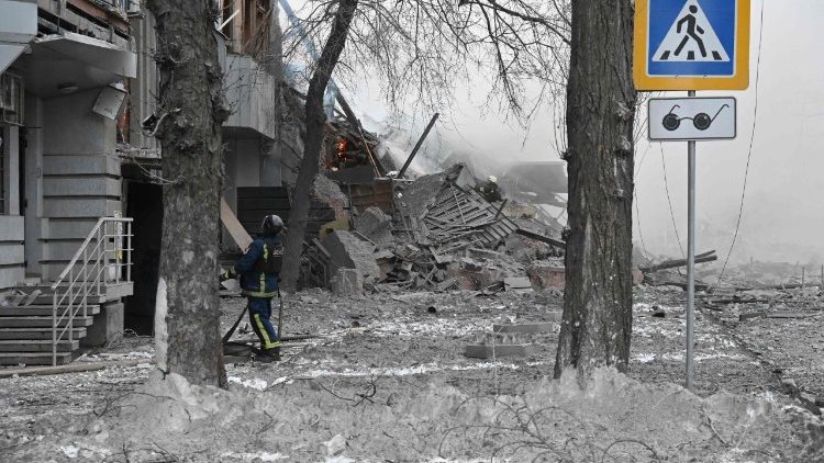 Um bombeiro ucraniano est&aacute; em frente a um pr&eacute;dio residencial danificado ap&oacute;s um ataque a&eacute;reo russo em Kharkiv, em 2 de janeiro de 2026, durante a invas&atilde;o russa da Ucr&acirc;nia. (Foto de SERGEY BOBOK / AFP)
