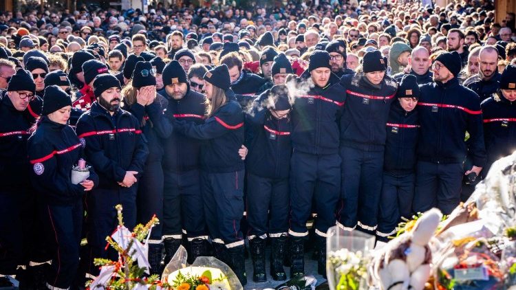 Bombeiros do município de Crans-Montana em torno de um memorial improvisado em homenagem às vítimas do incêndio.   (Foto de MAXIME SCHMID / AFP)