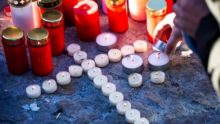 Um enlutado acende velas em um memorial improvisado para prestar suas homenagens, depositando flores, velas e mensagens perto do bar Constellation, em 4 de janeiro de 2026, em Crans-Montana, em memória das vítimas do incêndio que devastou o local na luxuosa estação de esqui alpina na véspera de Ano Novo. As autoridades que investigam o incêndio na estação de esqui suíça de Crans-Montana identificaram 24 das 40 pessoas mortas, incluindo 11 menores e seis estrangeiros, informou a polícia em 4 de janeiro de 2026. Além disso, 119 pessoas ficaram feridas no incêndio, a maioria em estado grave, segundo o último balanço. (Foto de MAXIME SCHMID / AFP)