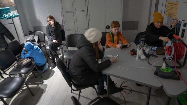 Moradores locais se re&uacute;nem no Ponto de Invencibilidade em Kiev, em 9 de janeiro de 2026, onde podem carregar seus dispositivos e se aquecer, ap&oacute;s ataques russos com m&iacute;sseis e drones &agrave; infraestrutura energ&eacute;tica ucraniana em meio &agrave; invas&atilde;o russa da Ucr&acirc;nia. Os cortes generalizados no fornecimento de aquecimento, causados ​​pelos ataques russos a Kiev, devem durar at&eacute; o fim de semana, e o prefeito da capital pediu aos moradores que deixem a cidade temporariamente, j&aacute; que as temperaturas abaixo de zero devem cair ainda mais. (Foto de Andrew Kravchenko / AFP)