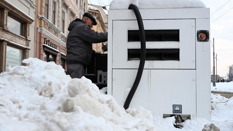 Um funcion&aacute;rio reabastece um gerador de energia do lado de fora de uma loja durante um corte de energia programado no centro de Lviv, ap&oacute;s ataques russos com m&iacute;sseis e drones &agrave; infraestrutura energ&eacute;tica ucraniana em meio &agrave; invas&atilde;o russa da Ucr&acirc;nia, em 13 de janeiro de 2026. (Foto de YURIY DYACHYSHYN / AFP)