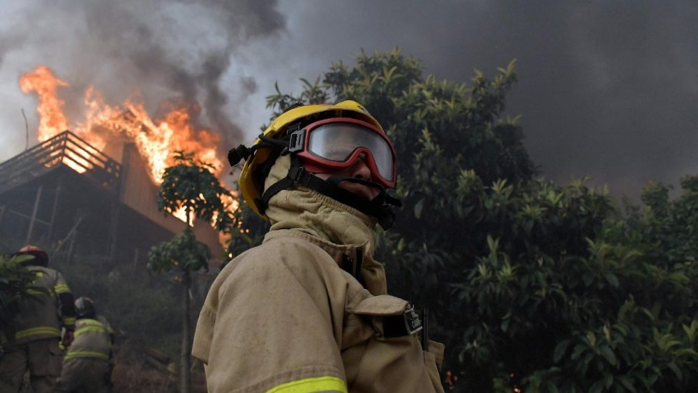 Bombeiros tentam extinguir uma casa em chamas durante um incêndio florestal em Concepción, Chile, em 18 de janeiro de 2026. O presidente chileno, Gabriel Boric, declarou estado de emergência em 18 de janeiro para duas regiões do sul do país, onde incêndios florestais devastadores forçaram cerca de 20.000 pessoas a evacuarem suas casas. (Foto de GUILLERMO SALGADO / AFP)