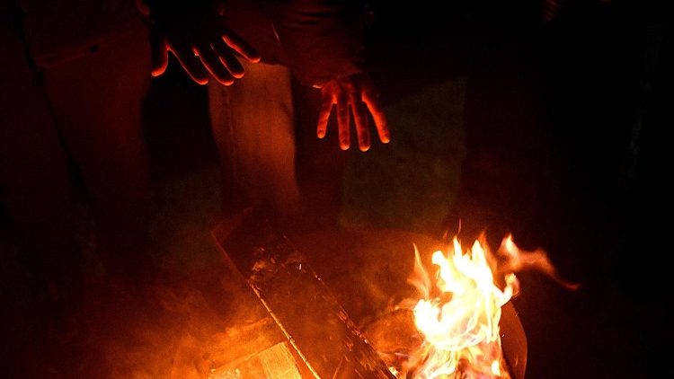 Moradores locais se re&uacute;nem em volta de uma fogueira durante uma festa ao ar livre para se aquecerem, j&aacute; que muitos apartamentos permanecem sem aquecimento em Kiev, em 18 de janeiro de 2026, em meio &agrave; invas&atilde;o russa da Ucr&acirc;nia. Os ataques russos deixaram a rede el&eacute;trica da Ucr&acirc;nia &agrave; beira do colapso e interromperam o fornecimento de energia e &aacute;gua para milh&otilde;es de pessoas nas &uacute;ltimas semanas. (Foto de Sergei Gapon / AFP)