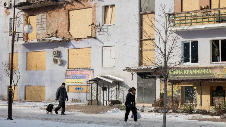 Moradores locais caminham ao lado de um pr&eacute;dio residencial danificado em Kramatorsk, no leste da Ucr&acirc;nia, em 20 de janeiro de 2026, em meio &agrave; invas&atilde;o russa da Ucr&acirc;nia. (Foto de Tetiana DZHAFAROVA / AFP)