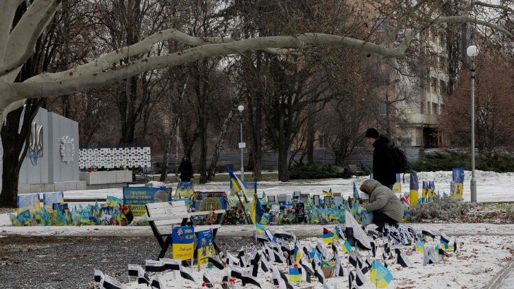 Moradores locais observam um memorial em homenagem aos soldados ucranianos em Zaporizhzhia, em 1&ordm; de fevereiro de 2026, em meio &agrave; invas&atilde;o russa da Ucr&acirc;nia. (Foto de Tetiana DZHAFAROVA / AFP)