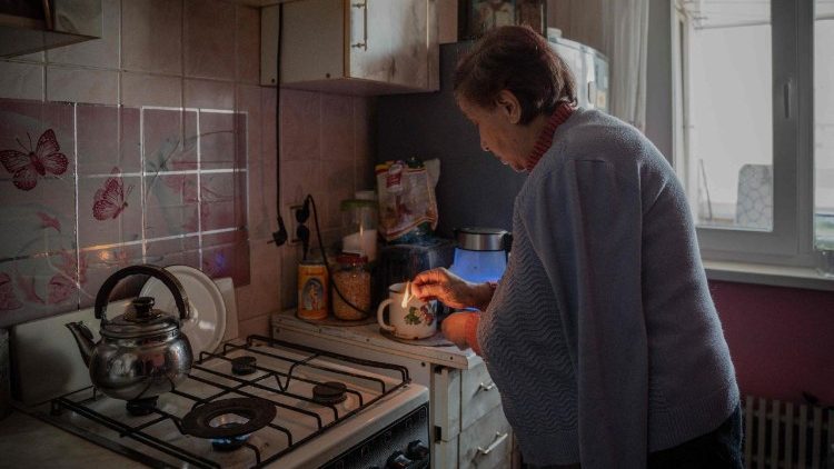 Valentyna Kucherenko, de 75 anos, acende um fog&atilde;o a g&aacute;s para se aquecer em seu apartamento durante um corte de aquecimento ap&oacute;s ataques russos em Kharkiv, em 4 de fevereiro de 2026, em meio &agrave; invas&atilde;o russa da Ucr&acirc;nia. (Foto de Ivan SAMOILOV / AFP)