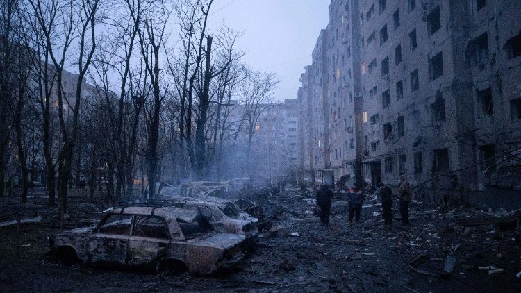 Nesta fotografia divulgada pela assessoria de imprensa da 93&ordf; Brigada Mecanizada Separada de Kholodnyi Yar das For&ccedil;as Terrestres da Ucr&acirc;nia em 8 de fevereiro de 2026, moradores locais posam ao lado de carros incendiados no p&aacute;tio de um pr&eacute;dio residencial danificado ap&oacute;s um ataque a&eacute;reo em Kramatorsk, regi&atilde;o de Donetsk, durante a invas&atilde;o russa da Ucr&acirc;nia. (Foto de Iryna Rybakova / 93&ordf; Brigada Mecanizada Separada de Kholodnyi Yar / AFP)