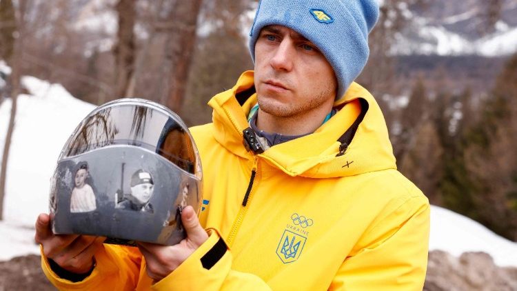 O atleta ucraniano de skeleton Vladyslav Heraskevych segura seu capacete, que retrata v&iacute;timas da guerra de seu pa&iacute;s contra a R&uacute;ssia, em Cortina d'Ampezzo, em 12 de fevereiro de 2026. Heraskevych foi desclassificado dos Jogos Ol&iacute;mpicos de Inverno em 12 de fevereiro de 2026, ap&oacute;s se recusar a voltar atr&aacute;s em rela&ccedil;&atilde;o ao seu capacete proibido, que retrata v&iacute;timas da guerra de seu pa&iacute;s contra a R&uacute;ssia. O Comit&ecirc; Ol&iacute;mpico Internacional afirmou que ele foi expulso dos Jogos de Mil&atilde;o-Cortina "ap&oacute;s se recusar a seguir as diretrizes do COI sobre a liberdade de express&atilde;o dos atletas". (Foto de Odd ANDERSEN / AFP)