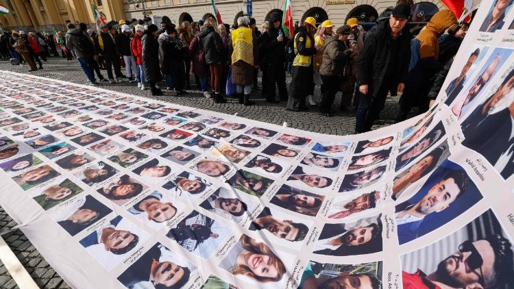 Manifestantes exibem uma faixa com retratos de v&iacute;timas do governo iraniano durante um protesto  em Munique, Alemanha.