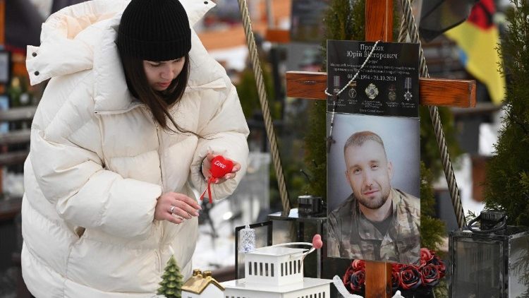 Iryna, vi&uacute;va de Yuriy, um soldado ucraniano morto em combate, exibe um cora&ccedil;&atilde;o em seu t&uacute;mulo no Dia dos Namorados, no Cemit&eacute;rio Militar de Lychakiv, em Lviv, em 14 de fevereiro de 2026, em meio &agrave; invas&atilde;o russa da Ucr&acirc;nia. (Foto de YURIY DYACHYSHYN / AFP)