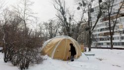 ಕೈವ್‌ನಲ್ಲಿರುವ ತುರ್ತು ಸೇವೆಗಳ ಟೆಂಟ್‌ನ ಹಿಂದೆ ಒಬ್ಬ ವ್ಯಕ್ತಿ ನಡೆದುಕೊಂಡು ಹೋಗುತ್ತಿದ್ದಾನೆ