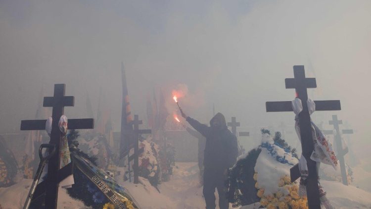 „&Uacute;častn&iacute;k pohřbu drž&iacute; d&yacute;movnici během pohřbu Oleksandra Krasikova s přezd&iacute;vkou ‚Sambo‘. Krasikov byl ukrajinsk&yacute; voj&aacute;k a člen ultras fotbalov&eacute;ho klubu Dynamo Kyjev, kter&yacute; padl v bitvě o Kyjev 20. &uacute;nora 2026 během rusk&eacute; invaze na Ukrajinu.“