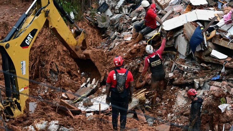 Bombeiros trabalham para resgatar corpo entre os escombros ap&oacute;s deslizamento de terra no bairro Parque Jardim Burnier, em Juiz de Fora.