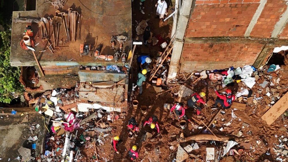 Esta vista aérea mostra equipes de resgate buscando vítimas em meio aos escombros após um deslizamento de terra causado por fortes chuvas no bairro Parque Jardim Burnier, em Juiz de Fora, Minas Gerais, Brasil, em 26 de fevereiro de 2026. (Foto de Pablo Porciúncula / AFP)