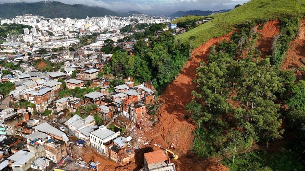 Esta vista aérea mostra equipes de resgate buscando vítimas em meio aos escombros após um deslizamento de terra causado por fortes chuvas no bairro Parque Jardim Burnier, em Juiz de Fora, Minas Gerais, Brasil, em 26 de fevereiro de 2026.  (Foto de Pablo Porciúncula / AFP)