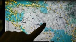 Uma pessoa aponta para uma página no site Flightradar 24 que mostra voos civis evitando o espaço aéreo iraniano e iraquiano, em Paris, em 1º de março de 2026.