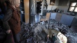 Una famiglia palestinese osserva i danni provocati da un missile iraniano a Bidya, in Cisgiordania