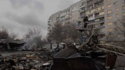 FILE PHOTO: A Ukrainian municipal worker cuts down a tree at the site of a recent Russian air attack in front of a damaged residential building in Zaporizhzhia