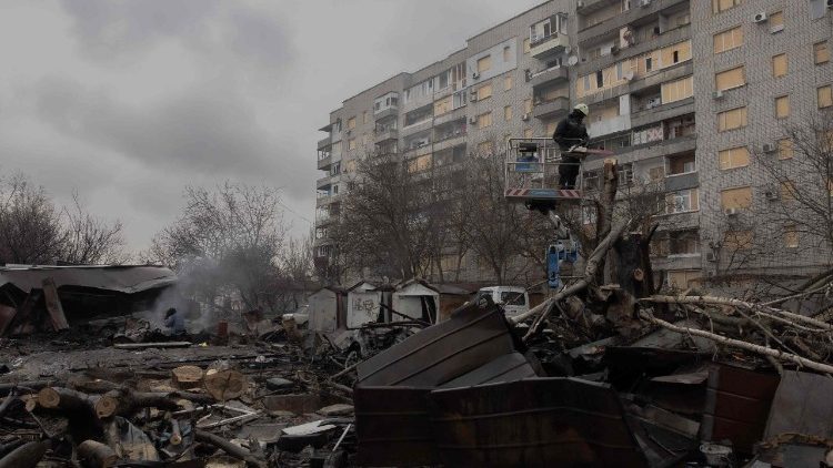 FILE PHOTO: A Ukrainian municipal worker cuts down a tree at the site of a recent Russian air attack in front of a damaged residential building in Zaporizhzhia