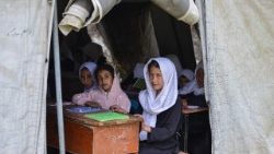 Bambine afghane partecipano a una lezione durante l'inizio del nuovo anno scolastico, in una tenda nella scuola del distretto di Fayzabad