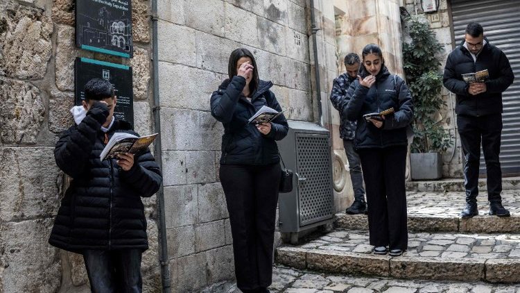  पवित्र शुक्रवार को होली सेपल्कर गिरजाघर के बंद दरवाजे के पास से गुजरते हुए विश्वासी 