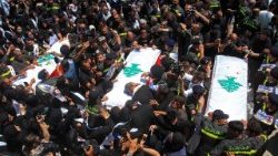 Mourners gather round the coffins of three Lebanese Civil Defence members killed in an Israeli strike