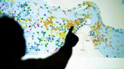 A photo illustration taken in Nicosia on May 4, 2026, shows a person in front of a large screen displaying vessel movements in the Strait of Hormuz on a ship-tracking website. 