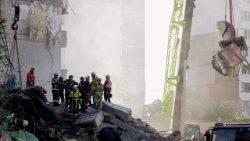 Equipes de resgate e socorristas atuam no local de um prédio residencial parcialmente destruído após ataques de drones e mísseis russos em Kiev, em 14 de maio de 2026, em meio à invasão russa da Ucrânia. (Foto de Tetiana DZHAFAROVA / AFP)