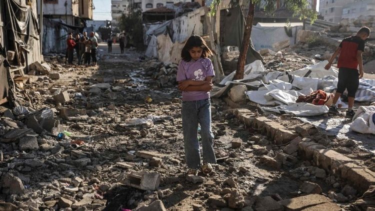 Uma menina palestina caminha pelos escombros da cidade de Gaza