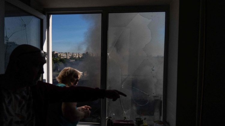Moradores locais observam a paisagem da janela de seu apartamento em um pr&eacute;dio residencial de v&aacute;rios andares, danificado ap&oacute;s os ataques maci&ccedil;os de m&iacute;sseis e drones russos contra Kiev em 2 de junho de 2026, em meio &agrave; invas&atilde;o russa da Ucr&acirc;nia. A R&uacute;ssia bombardeou a Ucr&acirc;nia com centenas de drones e dezenas de m&iacute;sseis na madrugada de 2 de junho de 2026, matando pelo menos 11 pessoas, ap&oacute;s amea&ccedil;ar um ataque em larga escala e alertar cidad&atilde;os estrangeiros para que deixassem Kiev. (Foto de OLEKSII FILIPPOV / AFP)