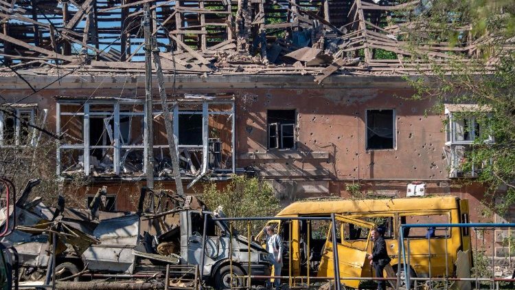 Moradores locais inspecionam carros destru&iacute;dos em frente a um pr&eacute;dio gravemente danificado ap&oacute;s um ataque a&eacute;reo em Dnipro, em 2 de junho de 2026, em meio &agrave; invas&atilde;o russa da Ucr&acirc;nia. (Foto de Mykola Synelnykov / AFP)