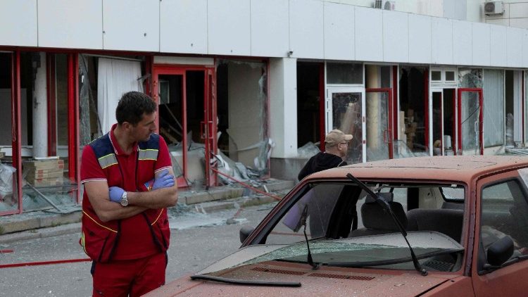 Um param&eacute;dico ucraniano est&aacute; ao lado de um carro danificado em frente a um centro m&eacute;dico tamb&eacute;m danificado ap&oacute;s um ataque a&eacute;reo em Kiev, em 2 de junho de 2026, durante a invas&atilde;o russa da Ucr&acirc;nia. A R&uacute;ssia bombardeou a Ucr&acirc;nia com centenas de drones e dezenas de m&iacute;sseis na madrugada de 2 de junho de 2026, matando pelo menos 11 pessoas, depois de amea&ccedil;ar um ataque em larga escala e alertar cidad&atilde;os estrangeiros para que deixassem Kiev. (Foto de Serhii Okunev / AFP)
