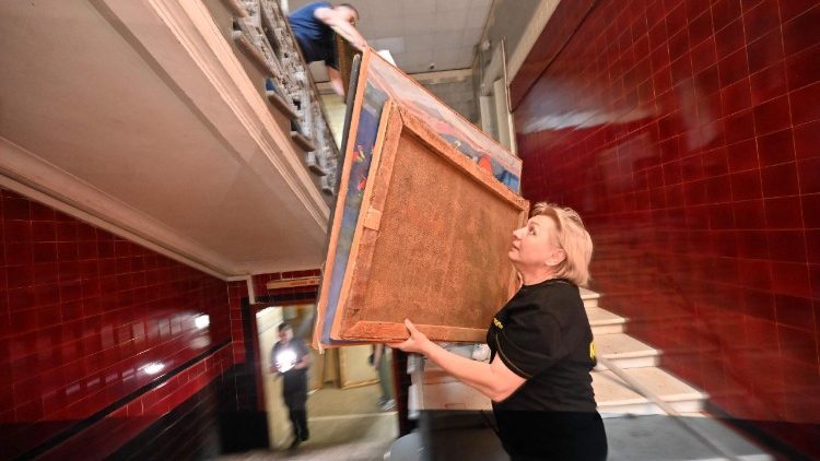 Pessoas transportam quadros para o por&atilde;o do Museu de Arte de Kharkiv, danificado por um ataque de drone em Kharkiv em 14 de junho de 2026, durante a invas&atilde;o russa da Ucr&acirc;nia. (Foto de SERGEY BOBOK / AFP)