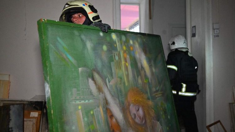 Bombeiros transportam pinturas para o por&atilde;o do Museu de Arte de Kharkiv, danificado por um ataque de drone em Kharkiv em 14 de junho de 2026, durante a invas&atilde;o russa da Ucr&acirc;nia. (Foto de SERGEY BOBOK / AFP)